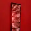 An advanced red light therapy panel on a red wall., red light therapy
