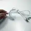 A person is holding the REDi Lumident with Power Pack with a cord attached to it.