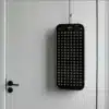 An advanced red light therapy panel hanging on a white door., red light therapy