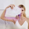 A woman holding up a REDi Mask with a light on it.